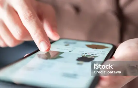 Nahaufnahme einer Hand, die durch eine App auf einem Smartphone scrollt