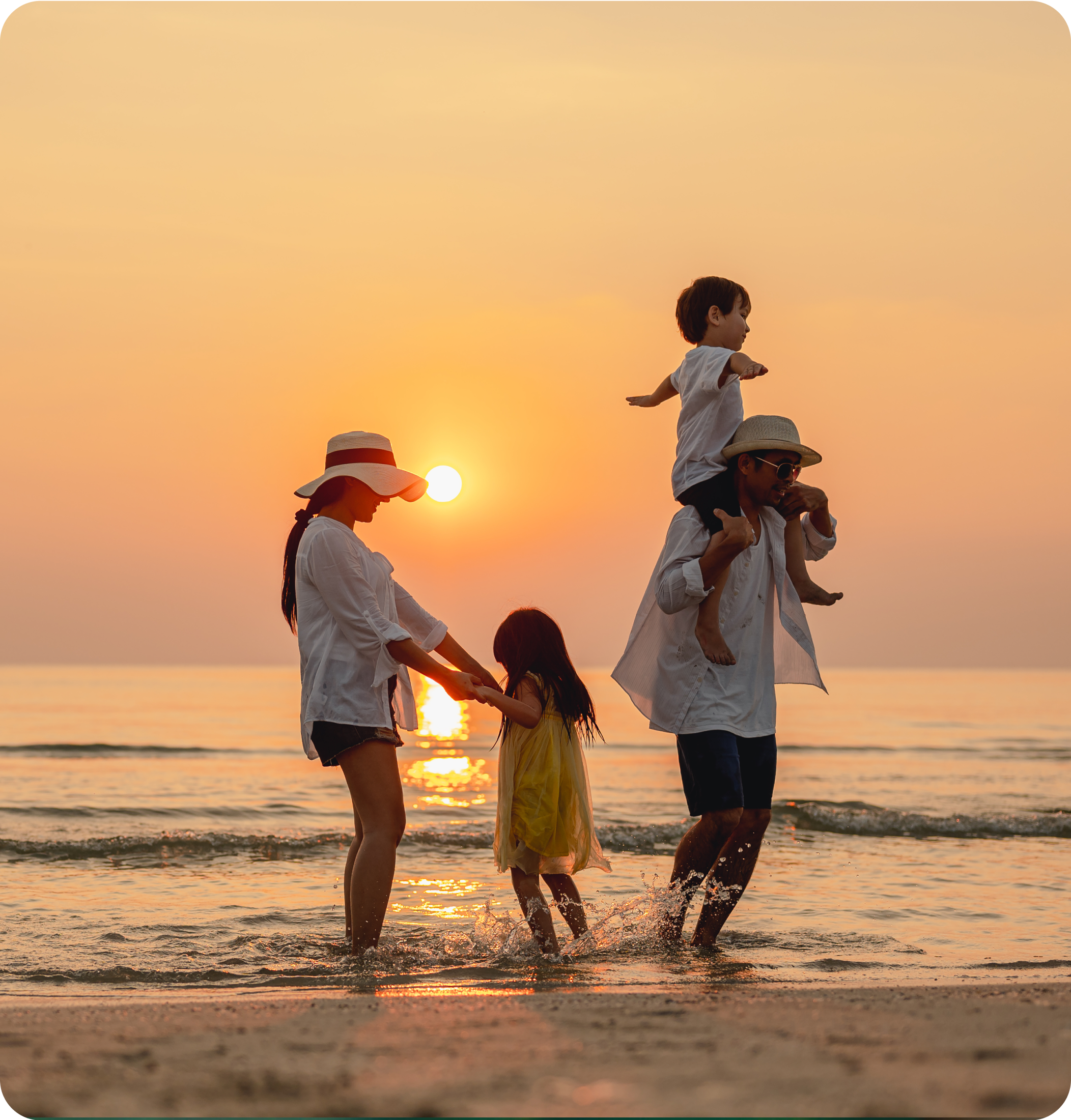 Familie am Strand bei Sonnenuntergang, Eltern mit Kindern im Wasser spielend