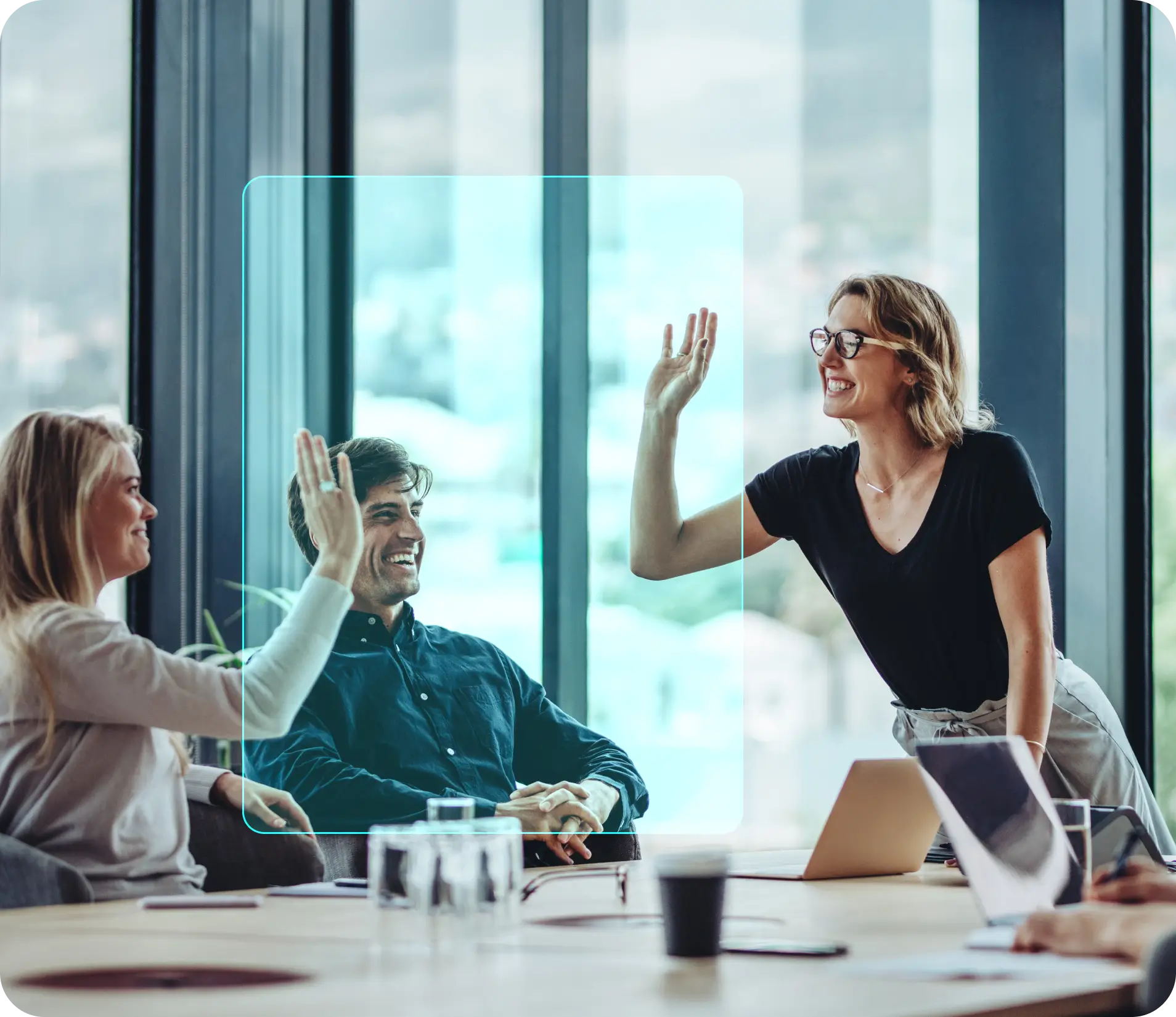 Drei Kollegen im Büro lachen und geben sich gegenseitig ein High-Five