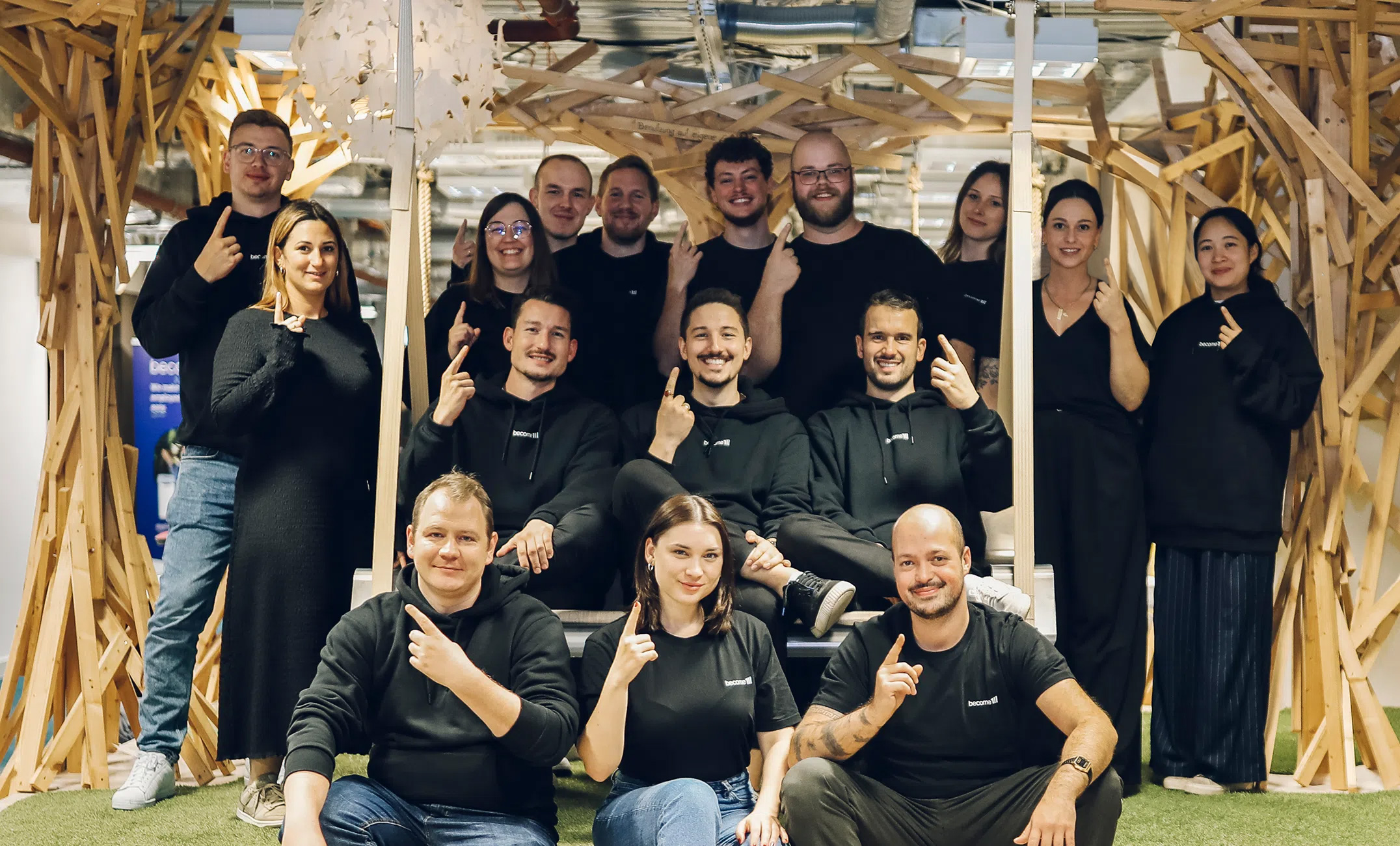 Das become.1 Team posiert zusammen in den Büroräumen und symbolisiert den Teamgeist und die become.1 Kultur