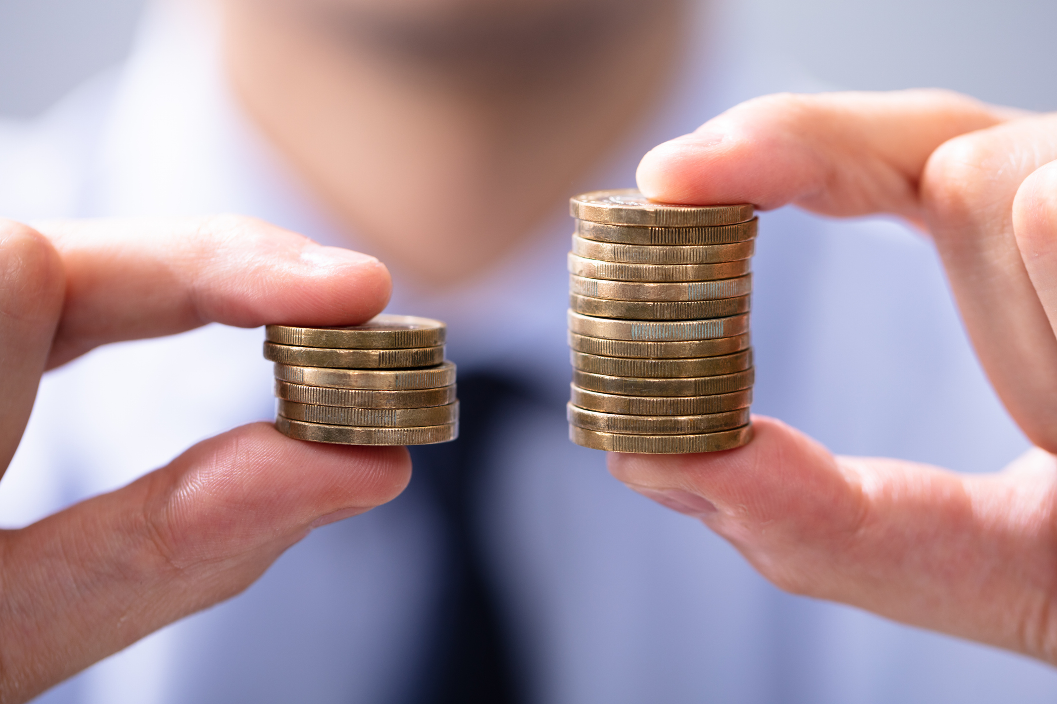 Vergleich von Geld: Ein höherer Münzstapel symbolisiert den Netto-Vorteil für Mitarbeiter durch die become.1 Sachbezüge